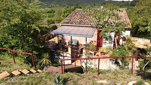 Una casa con techo de tejas, un porche cubierto y un jardín.
