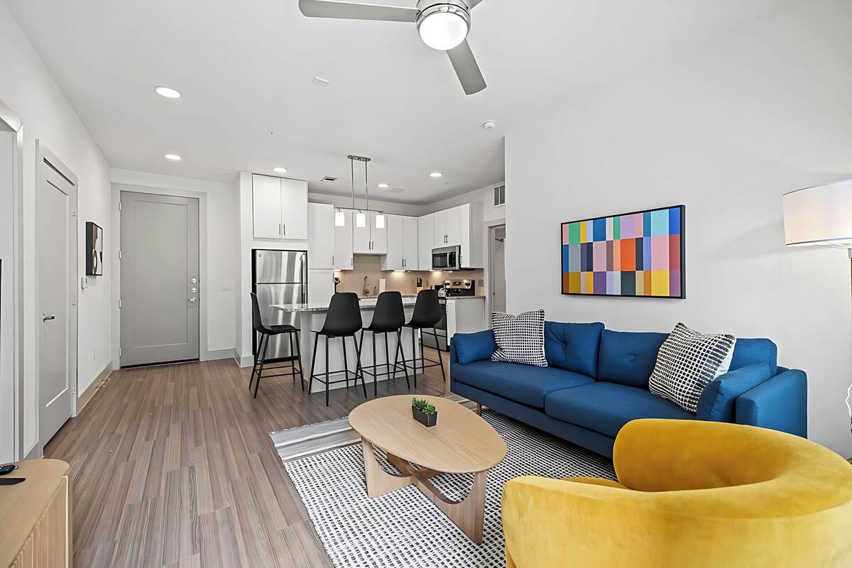 A modern apartment with a kitchen, dining area, and living room.