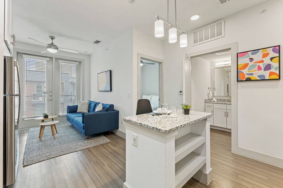 A modern apartment with a living room, kitchen, and dining area.