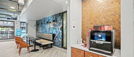 A modern interior with a seating area, a coffee machine, and a wall with a textured pattern.