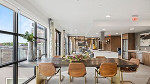 A modern kitchen with a large island, built-in appliances, and a view of the city. - Placemakr Austin Downtown, Apartments by Hilton (Austin)