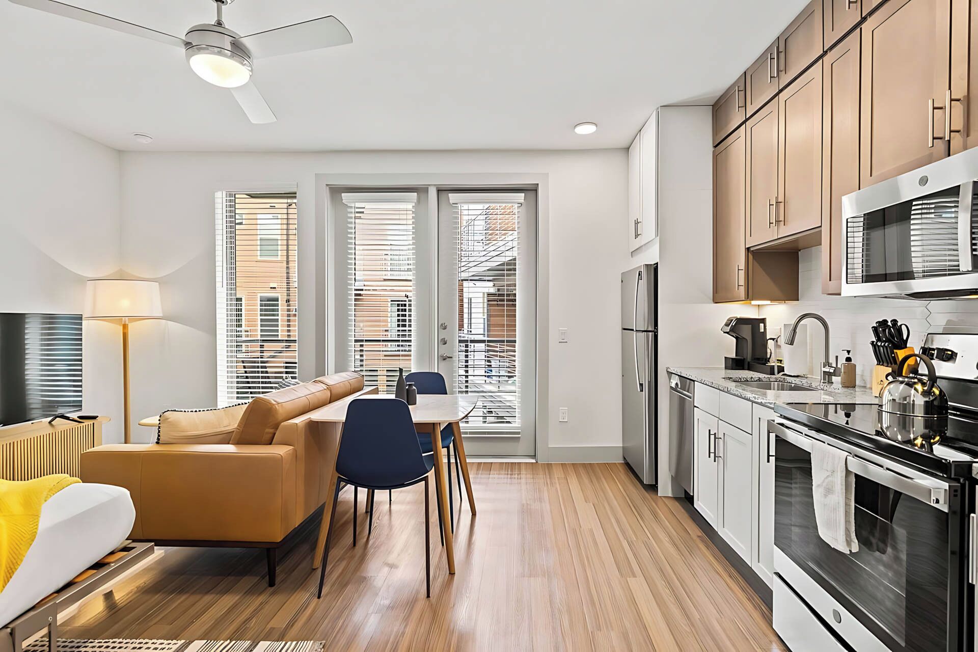 A modern apartment with a living room, dining area, and kitchen.