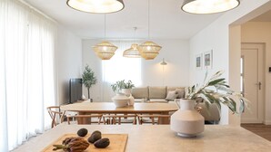 A modern living room with a wooden dining table, a sofa, and a large vase. - Beach front home in Maslenica with sauna (Maslenica)