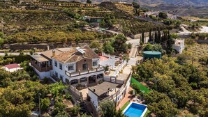 Une villa avec piscine, entourée d’une végétation luxuriante et de vignobles.