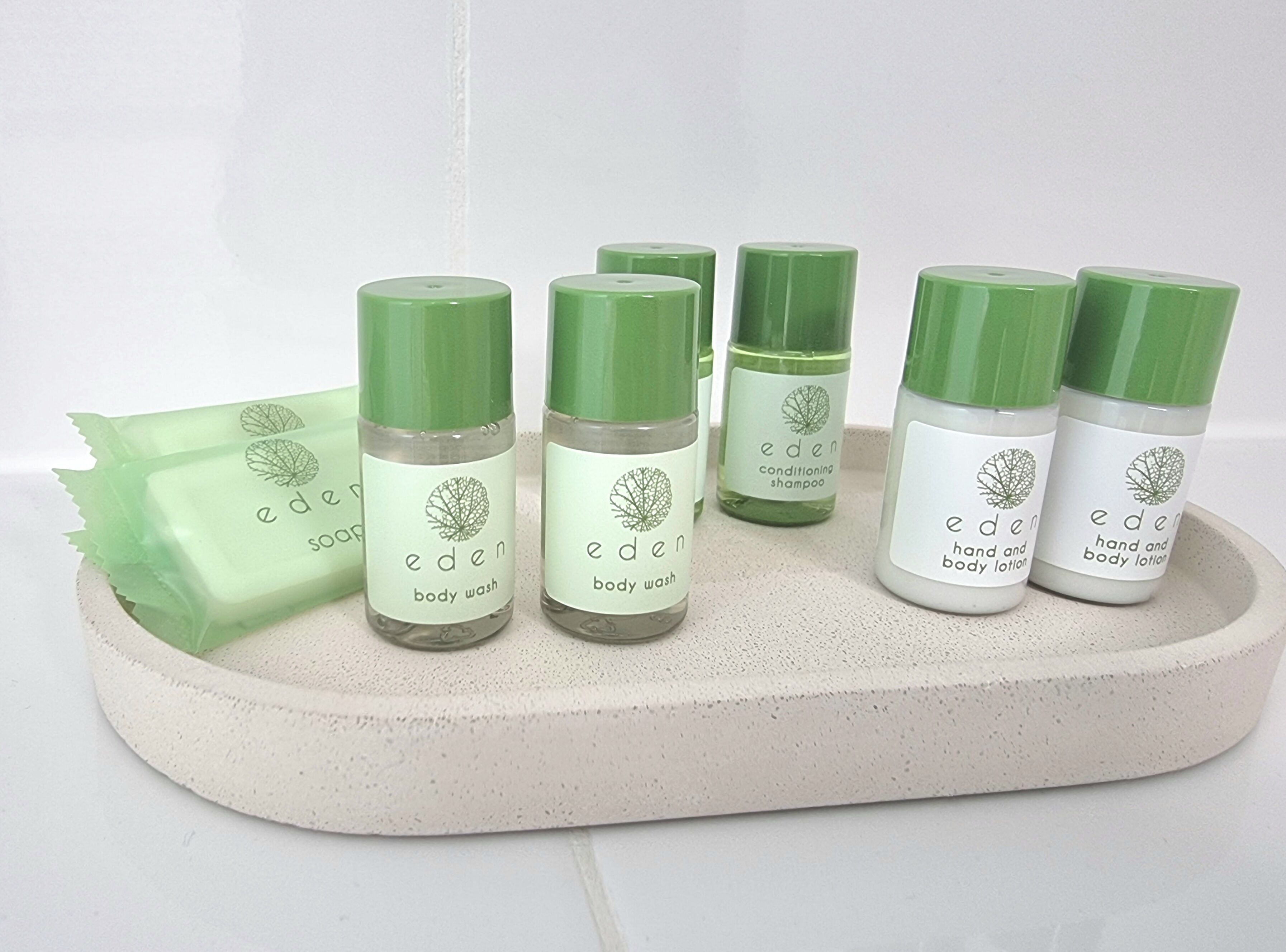 Una bandeja con seis botellas de gel y loción corporal Eden, y una pastilla de jabón.