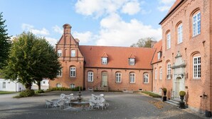 Ein historisches Gebäude mit Innenhof, Brunnen und einer Ziegel-Fassade.