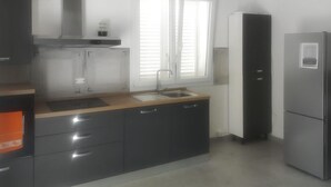 Una cocina con un lavamanos, estufa y refrigerador.