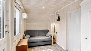 A cozy room with a grey sofa, a wooden bench, and a white door. - Beautiful home in Otterup with WiFi (Otterup)