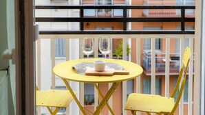 A yellow table with two chairs, two glasses, and a cup on a balcony with a railing. - Luci A Lago - MyHomeinComo (Como)
