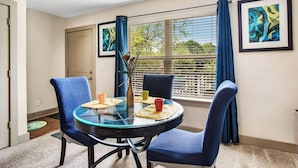 A dining area with a round glass table, blue upholstered chairs, and a vase with flowers. - New Spacious Home in the Heart of Downtown Atlanta (Atlanta)