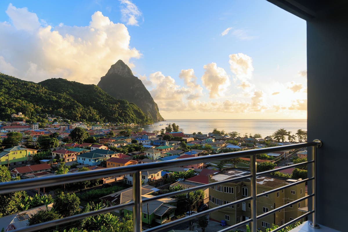 A coastal town with colorful buildings, a prominent mountain, and a view of the sea.