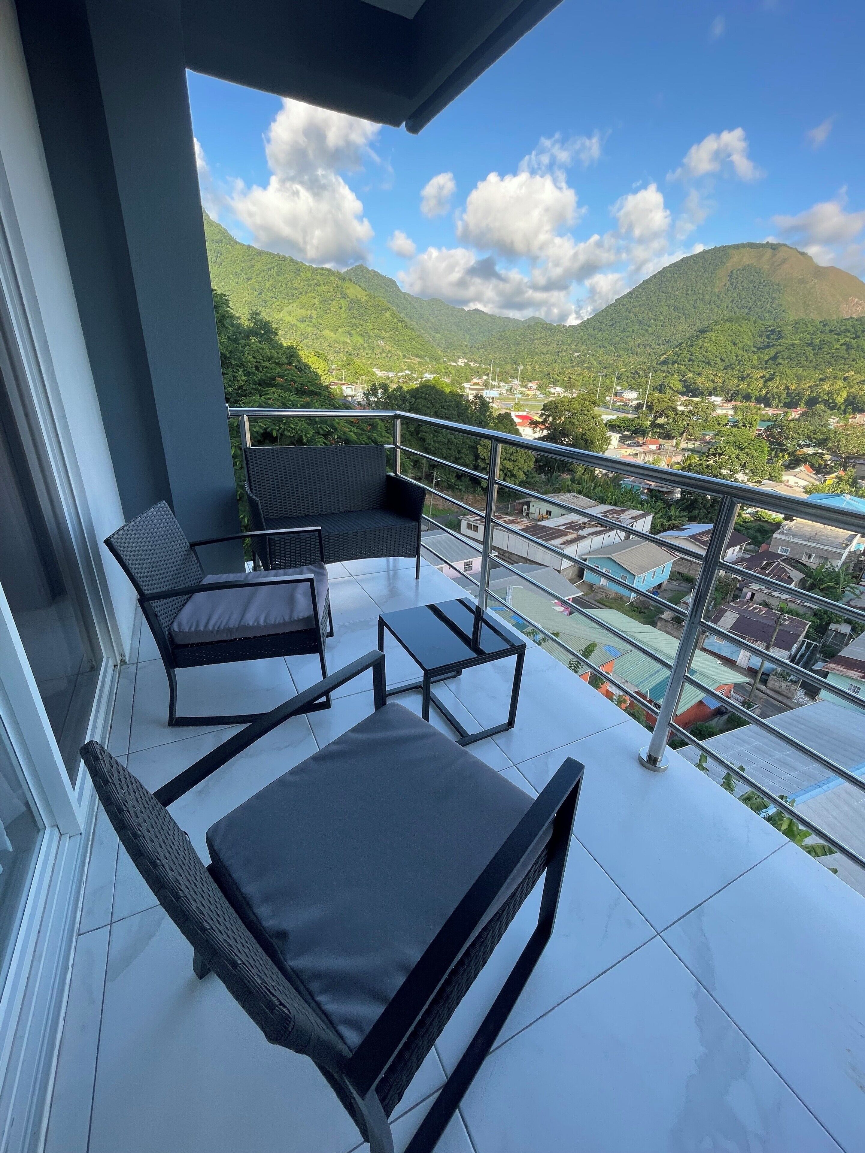 A balcony with a view of a mountainous landscape and a town below.