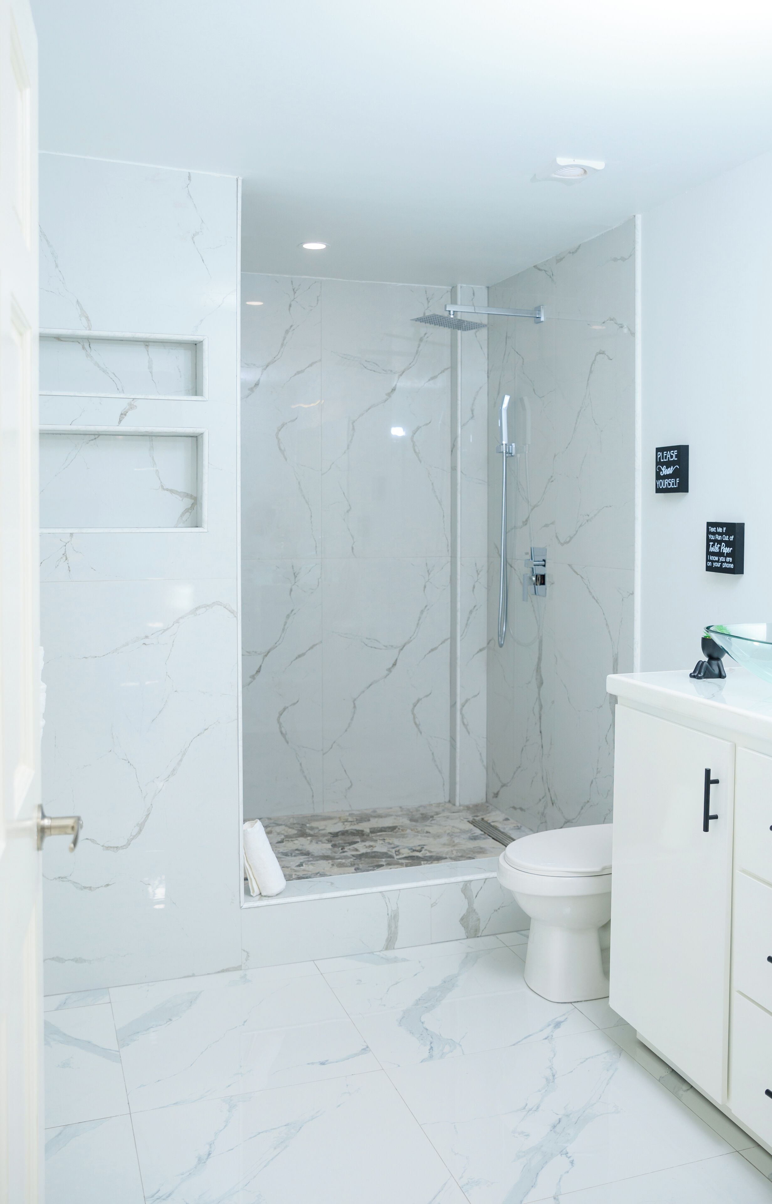 A bathroom with a shower, toilet, and vanity.