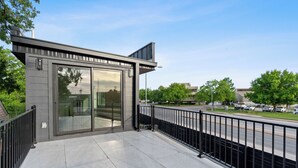 A modern building with a flat roof, large glass windows, and a metal railing. - Brand New Austin Downtown Home -Pool (Austin)