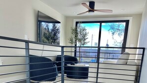 A multi-level interior with a staircase, a ceiling fan, and a view of the outdoors through large windows. - Brand New Austin Downtown Home -Pool (Austin)