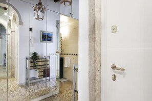 A bathroom with a shower, a towel rack, and a mirror.