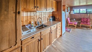 A wooden cabin interior with a kitchen featuring a sink, cabinets, and a dining area with a table and chairs. - Beautiful home in Gol with kitchen (Gol)