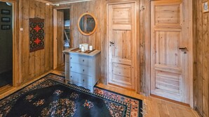 A wooden-paneled room with a dresser, a mirror, and two doors. - Beautiful home in Gol with kitchen (Gol)