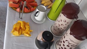 Mesa de buffet com diversos alimentos e utensílios de servir.