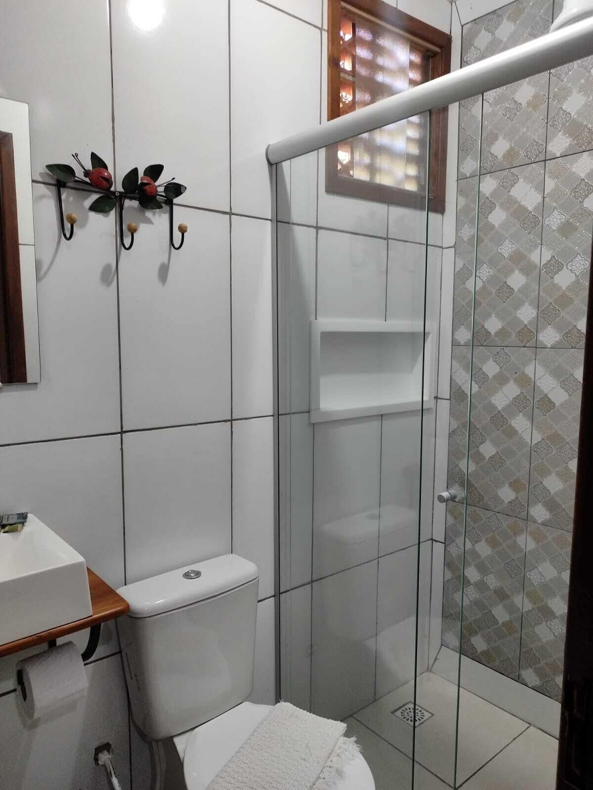 A small bathroom with a toilet, a sink, and a shower stall.