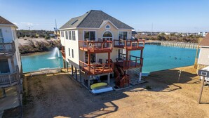 A multi-story building with a pool, outdoor seating, and a staircase leading to a deck. - 5064 McBride's Shore Thing * 2 Min Walk to Beach (Kill Devil Hills)
