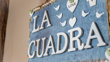 Segnaletica in denim con la scritta 'LA CUADRA' ed elementi decorativi.
