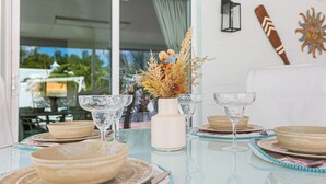A dining table set with bowls, glasses, and a vase with dried plants. - MADEIRA BEACH RETREAT WITH HEATED POOL. (Seminole)