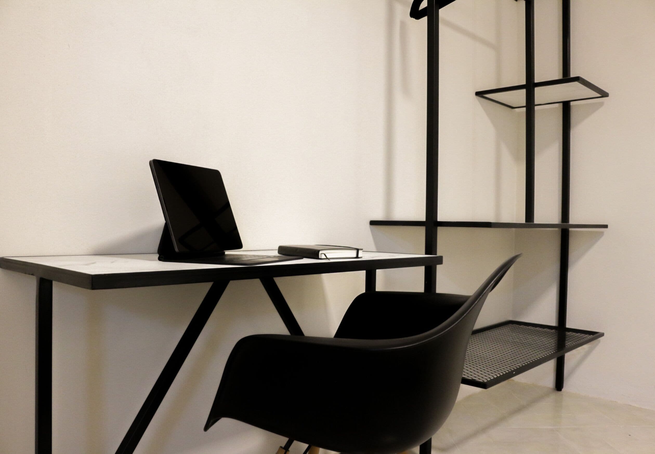 Un espace de bureau moderne comprenant un bureau, une chaise et un grand lampadaire élancé.