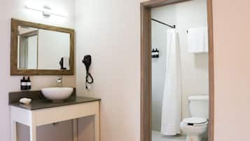 A bathroom with a sink, mirror, and toilet.