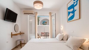 A bedroom with a bed, a TV, a mirror, and a painting. - Room 'Studio 3' with Private Terrace, Wi-Fi and Air Conditioning (Paros)