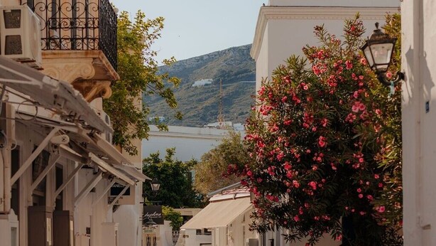 A narrow street with cobblestone pavement, white buildings, and a view of a body of water in the distance. - Studio Apartment '5' with Private Terrace, Wi-Fi and Air Conditioning (Paros)