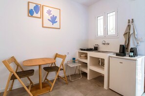Une petite cuisine équipée avec un coin repas comprenant une table, des chaises et un petit réfrigérateur.