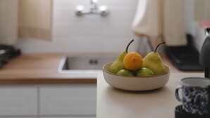 A kitchen with a bowl of fruit on the counter, a sink, and a window with curtains. - Studio Apartment '2' with Private Terrace, Wi-Fi and one Air Condition in the bedroom (Paros)