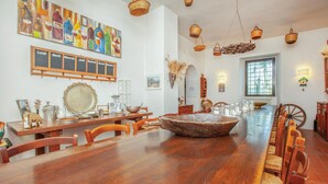 A dining area with a wooden table, chairs, and a large decorative bowl. There are hanging baskets and a window with a view. - Nice home in Tocco da Casauria (Tocco da Casauria)
