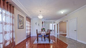 A dining room with a wooden table, chairs, and a chandelier. - Harmony House: 7-BR Multi family & Group Oasis with Dual Living (Richmond Hill)