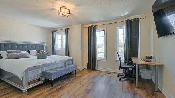 A bedroom with a bed, a desk, and a chair. - Harmony House: 7-BR Multi family & Group Oasis with Dual Living (Richmond Hill)