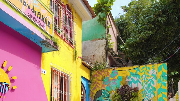 A colorful building with a mural, outdoor seating, and potted plants. - SOLCITY HOSTEL (Salvador)