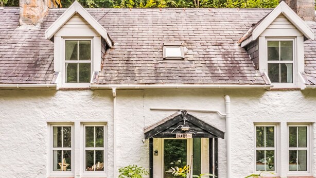 A white cottage with a gabled roof, a small porch with a door labeled "DANCE," and two windows on the upper floor. - Vacation home Dancot by Interhome (Drumnadrochit)