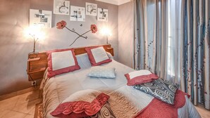 A bedroom with a bed, multiple pillows, a nightstand, and a wall with framed pictures. - 1 bedroom cozy home in Moustiers-Sainte-Marie (Moustiers-Sainte-Marie)