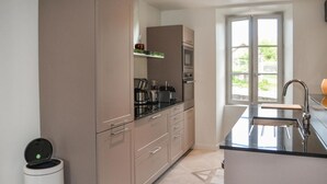 A modern kitchen with a built-in oven, microwave, and coffee maker. There is a window providing natural light and a view of the outdoors. - 3 bedroom nice home in Saint Robert (Saint Robert)
