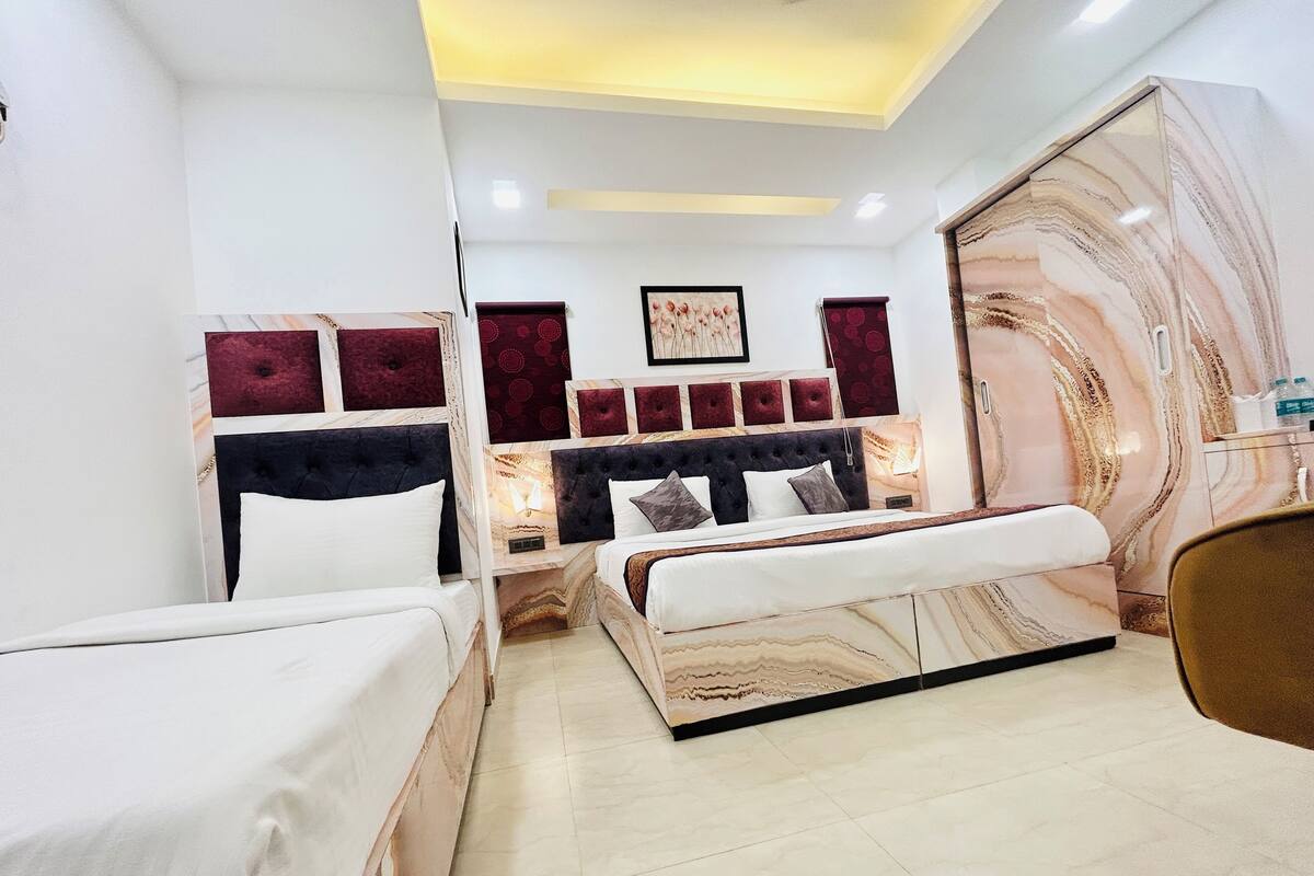 A hotel room with a bed, a bedside table, a mirror, and a wall with a marble-like pattern.