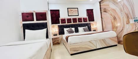 A hotel room with a bed, a bedside table, a mirror, and a wall with a marble-like pattern.