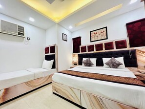 Quarto moderno com uma cama grande, um sofá menor e um ventilador de teto.