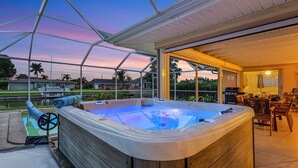 Een hottub met een houten buitenkant, een overdekte patio en uitzicht op de omgeving.