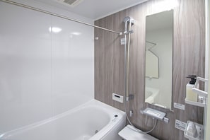 A modern bathroom with a bathtub, a shower, and a vanity with a mirror.