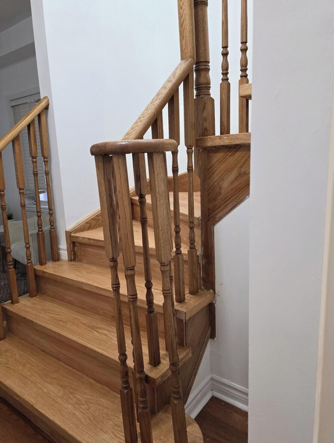 Una escalera de madera con barandilla y descansillo.