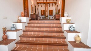 A staircase with terracotta steps leading to a landing with a wooden ceiling and a mirror. - Villa with private pool, the best sea views. (Almuñécar)
