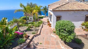 A coastal property with a paved pathway leading to a white building with a tiled roof. - Villa with private pool, the best sea views. (Almuñécar)