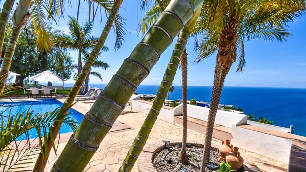 A pool area with palm trees, a view of the ocean, and outdoor seating. - Villa with private pool, the best sea views. (Almuñécar)