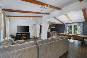 A spacious living area with a large sectional sofa, a flat-screen TV, and a fireplace.